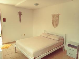 a bedroom with a white bed and a dresser at Mountain View in Curitiba