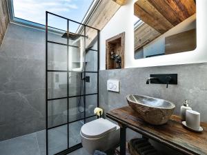 uma casa de banho com um lavatório e um WC em das brunn - Luxus Chalet em Kirchberg in Tirol