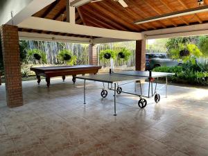 una mesa de ping pong en un patio con piscina en Casa Finca El Encanto en Santa Fe de Antioquia, en Santa Fe de Antioquia