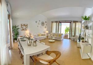 uma sala de estar com uma mesa branca e cadeiras em Villa Los Pinares de Monaco en Roche, Conil, Cádiz em Conil de la Frontera