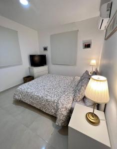 1 dormitorio con 1 cama y 1 mesa con lámpara en Private Pool View 2BDR in Los Corales Punta Cana, en Punta Cana