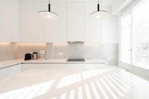 Biała kuchnia z białymi szafkami i oknem w obiekcie Upscale Athens Luxury Penthouse w Atenach
