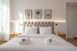 sypialnia z dużym białym łóżkiem z ręcznikami w obiekcie Upscale Athens Luxury Penthouse w Atenach
