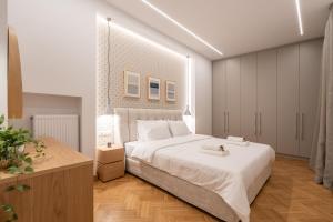 a bedroom with a large white bed and a wooden floor at Upscale Athens Luxury Penthouse in Athens