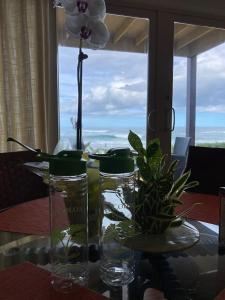 a glass table with a vase with a flower in it at Hanalei Colony Resort in Hanalei
