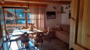 sala de estar con mesa, sillas y sofá en Apartma in Bungalov Jezerci, en Gozd Martuljek