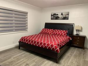 1 dormitorio con 1 cama con edredón rojo y ventana en Stylish & Spacious House for Ultimate Relaxation!, en Tracy