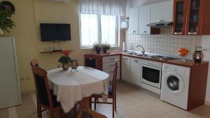 cocina con mesa, fogones y fregadero en Apartments Aurora Borik, en Zadar