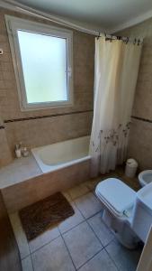 a bathroom with a tub and a toilet and a window at Confortmdp apartamentos in Mar del Plata
