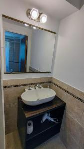 a bathroom with a sink and a large mirror at Confortmdp apartamentos in Mar del Plata