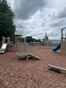 einen Spielplatz mit zwei Schaukeln und einer Rutsche in der Unterkunft ParkDean cherry tree holiday park in Great Yarmouth