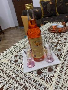 eine Flasche Alkohol auf einem Tisch mit zwei Gläsern in der Unterkunft Vila Demaj in Berat