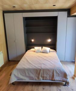 um quarto com uma cama grande e 2 almofadas em Departamento dos ambientes, muy cálido y luminoso, en el centro de SMA. 17V5 em San Martín de los Andes