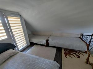 a small room with a bed and a window at Vikendica Ahatovići 2 in Sarajevo