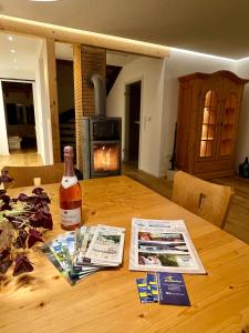 een fles wijn bovenop een houten tafel bij Ferienhaus Fuchseck in Bad Liebenzell