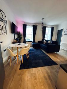 a living room with a table and a couch at Modern Town-Centre Apartment in Dumfries