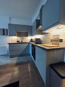 a kitchen with blue cabinets and a counter top at Modern Town-Centre Apartment in Dumfries