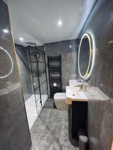 a bathroom with a toilet and a sink and a mirror at Modern Town-Centre Apartment in Dumfries