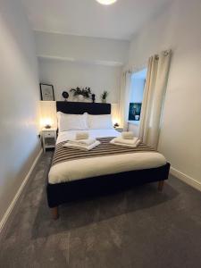 a bedroom with a large bed with two towels on it at Modern Town-Centre Apartment in Dumfries