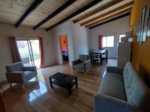 uma sala de estar com um sofá, cadeiras e uma mesa em Villas Laura em Punta Del Diablo