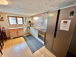 a kitchen with a refrigerator and a counter top at Lech Hostel in Lech am Arlberg