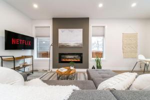 a living room with a couch and a fireplace at Chic Hideaway, 5BR near DT, Fireplace, King Bed, Fast Wifi, Sleeps 13! in Edmonton