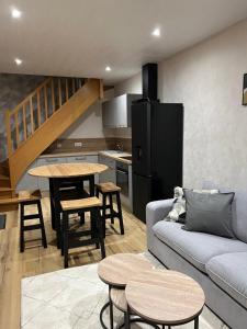 ein Wohnzimmer mit einem Sofa und einem Tisch sowie eine Küche in der Unterkunft Maison rénovée au cœur du Haut-Jura in Entre-Deux-Monts