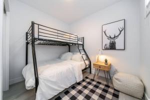 1 dormitorio con litera negra y suelo a cuadros en Chic Hideaway, 5BR near DT, Fireplace, King Bed, Fast Wifi, Sleeps 13! en Edmonton