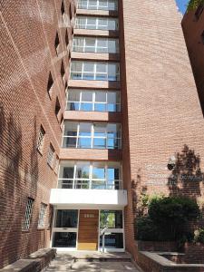 a tall brick building with a door in front of it at Confortmdp apartamentos in Mar del Plata