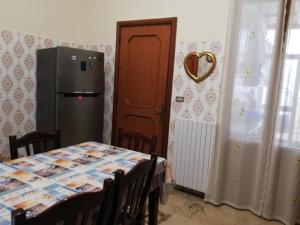 una cucina con tavolo e frigorifero di Villino Schiavone a Racale
