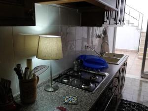 una cucina con piano cottura e lampada sul bancone di Villino Schiavone a Racale