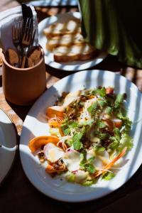 a plate of food with broccoli and carrots on a table at Mawamba Lodge in Tortuguero