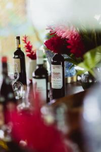 una mesa con dos botellas de vino y un jarrón con flores en Mawamba Lodge, en Tortuguero