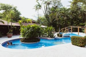 a swimming pool with two people in the water at Mawamba Lodge in Tortuguero