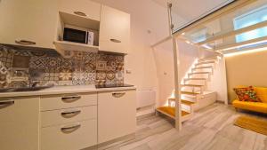 una cocina con fregadero y una escalera en una habitación en Trescene Room Locazione Breve Turistica, en Benevento