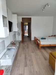 uma sala de estar com uma cama e um piso de madeira em Ferienwohnung - Apartment Pichlarn Irdning em Aigen im Ennstal