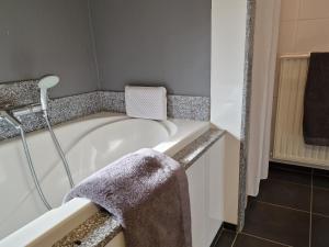 a bathroom with a bath tub with a towel at Our House in Breskens +26 photos