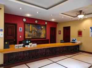 a hotel lobby with a reception desk and red walls at Grand Victoria Boutique Hotel in Loja