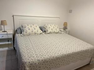 a white bed with two pillows and two lamps at Loid Patagonia in Puerto Madryn