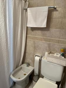 ein Badezimmer mit einer weißen Toilette und einem Waschbecken in der Unterkunft Loid Patagonia in Puerto Madryn