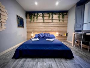 a bedroom with a blue bed with towels on it at Urban Blue Guest House in Olbia