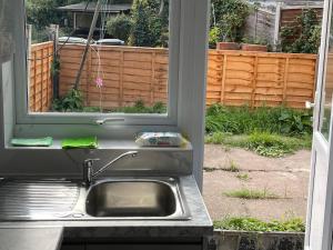 a kitchen with a sink and a window at Entire Lovely 2 bedroom apartment with private garden & free street parking in London