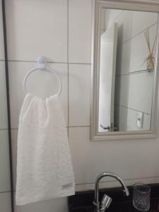 toalla blanca colgada en un toallero en el baño en FLAT - 200m da orla do Bessa, en João Pessoa