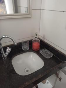 lavabo con una vela roja en la encimera en FLAT - 200m da orla do Bessa, en João Pessoa