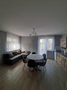 een woonkamer met een tafel en stoelen en een bank bij Wakacje nad morzem w Rusinowie in Rusinowo