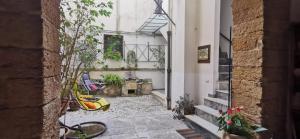 einen Innenhof mit Stühlen und Pflanzen in einem Gebäude in der Unterkunft Casa Bellini in Palermo