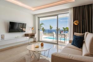 sala de estar con sofá, TV y mesa en Grand Horizon Luxury Boutique Apartments en Puerto Rico