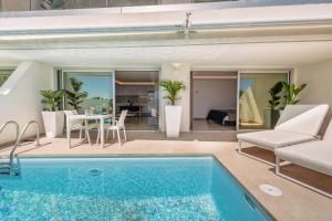 een villa met een zwembad en een woonkamer bij Grand Horizon Luxury Boutique Apartments in Puerto Rico de Gran Canaria