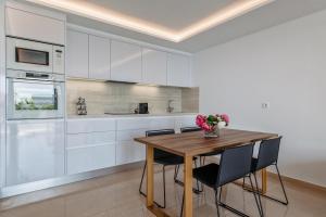 a kitchen with a wooden table and chairs at Grand Horizon Luxury Boutique Apartments in Puerto Rico de Gran Canaria