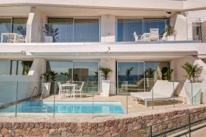 an exterior view of a house with a swimming pool at Grand Horizon Luxury Boutique Apartments in Puerto Rico de Gran Canaria